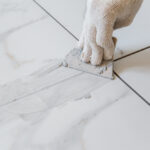 Grouting,Tiles,Seams,With,A,Rubber,Trowel.