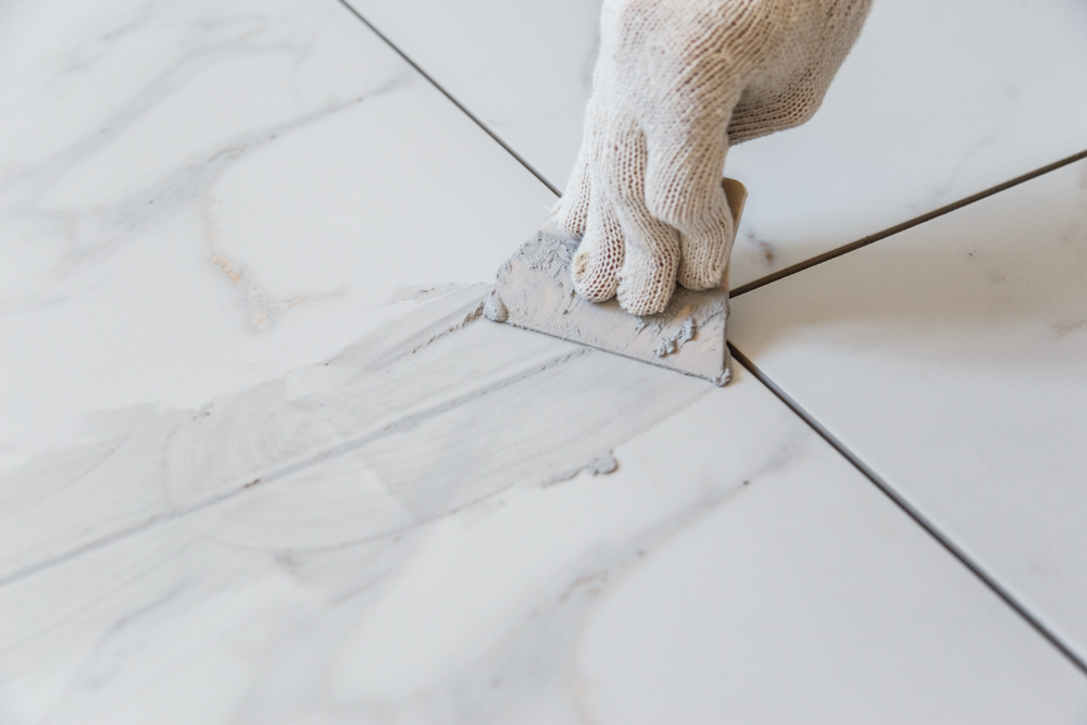 Grouting,Tiles,Seams,With,A,Rubber,Trowel.
